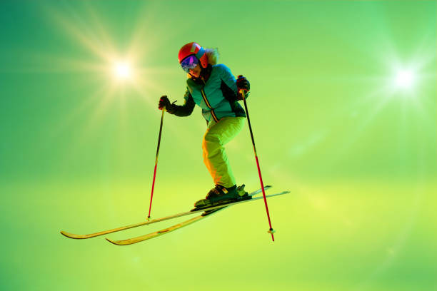 istock Professional female skier in motion, confident move under neon bright lights against green gradient studio background. 2191186949