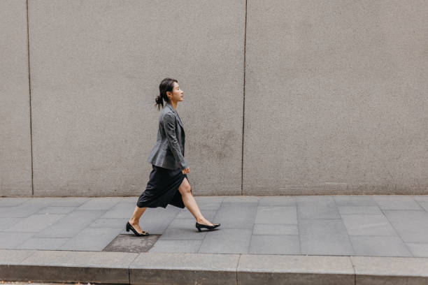 istock Businesswoman walking with purpose in urban setting 2191192116