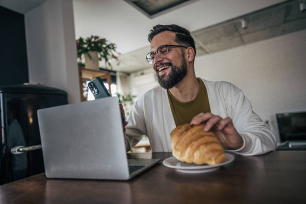 istock A cheerful smiling man is sitting at a table in an apartment and communicating with colleagues via video chat on the phone 2191193729