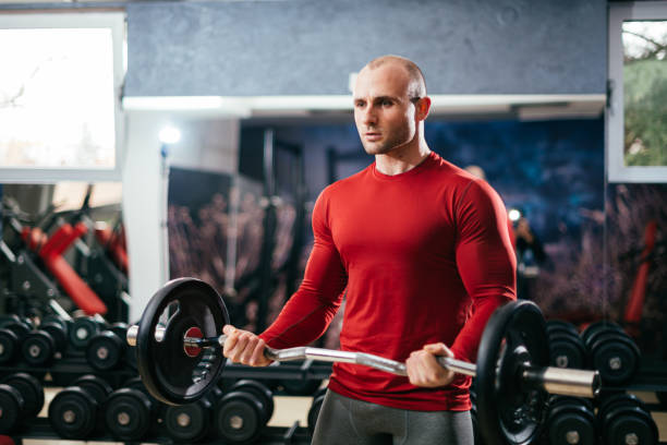 Man Lifting Dumbbells in Modern Gym Environment for Strength Training