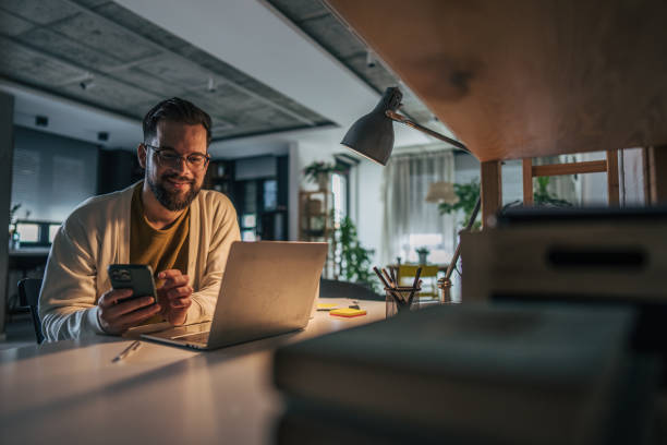 istock The photo shows a man sitting at a table in apartment, casually dressed and using phone 2191195901