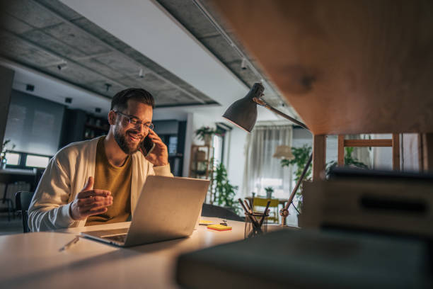 istock A man sitting at a table in apartment, casually dressed and deeply engaged in a phone conversation. 2191196373