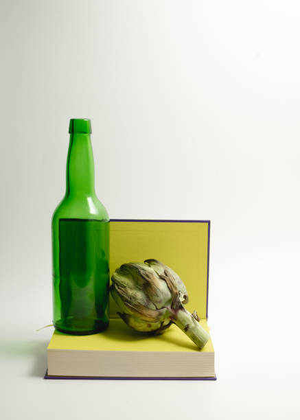 Still life with artichoke, wine bottle, and book