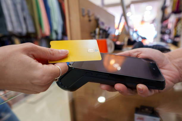 istock Woman tapping contactless credit card, completing secure retail transaction with quick, effortless digital payment method 2191197280