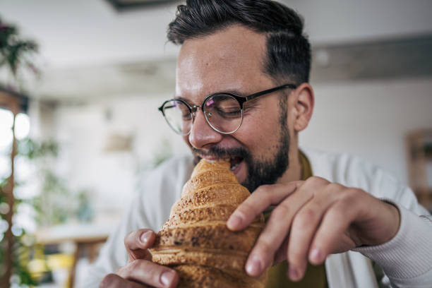 istock A man eating a croissant for breakfast 2191198721