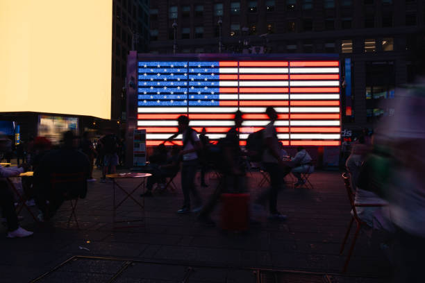 istock Tourist crowd in Times Square against a US Flag 2191201822