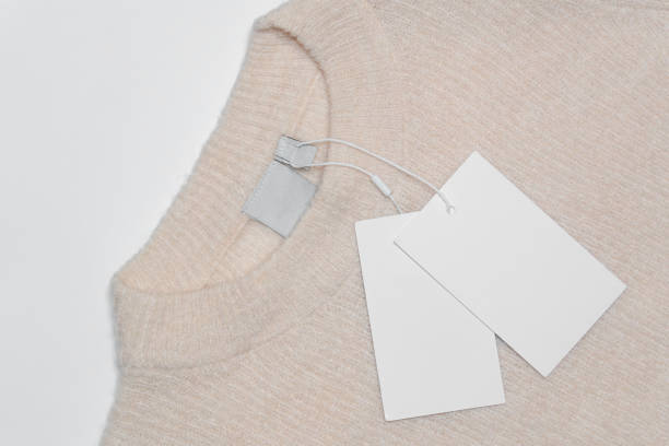 istock A soft beige wool sweater with a round neckline, showcasing an empty inner label and attached blank white tags. 2191202093