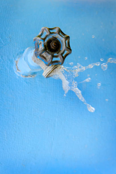 Water faucet spraying cool water flowing with drops blue leaky pipe
