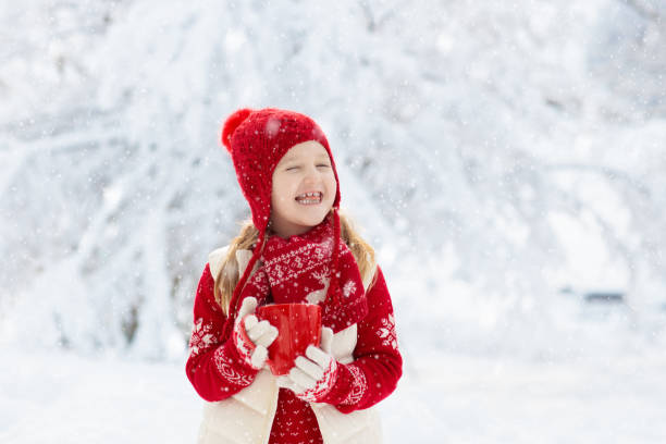 istock Child drinking chocolate on Christmas in snow 2191202213