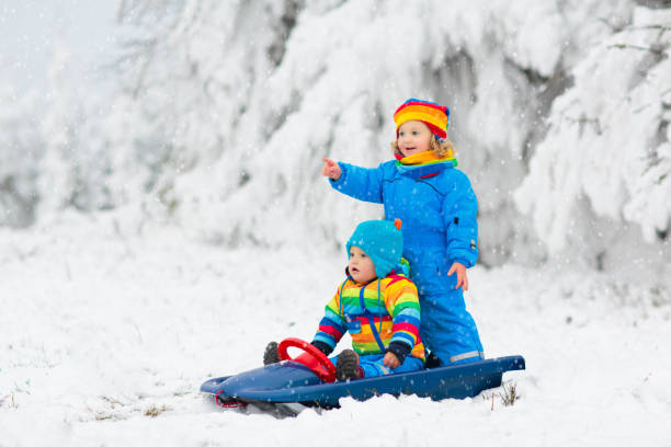 istock Kids play in snow in winter park 2191202853