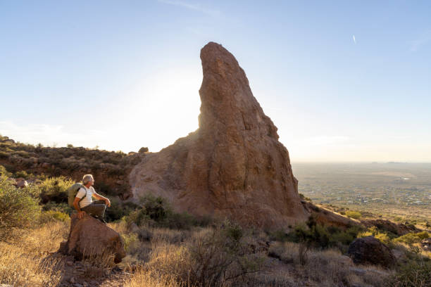 istock Mature man backpacker pauses on rock below pinnacle 2191202863