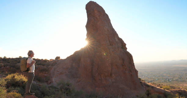 istock Mature backpacker climb onto rock below spire 2191202897