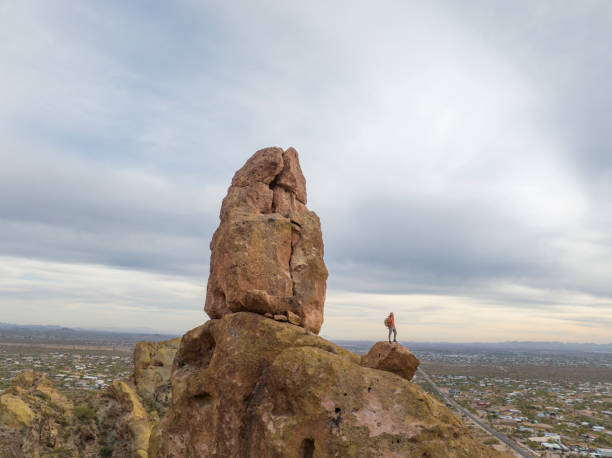 istock Aerial view of hiker pausing on rock below spire 2191203070