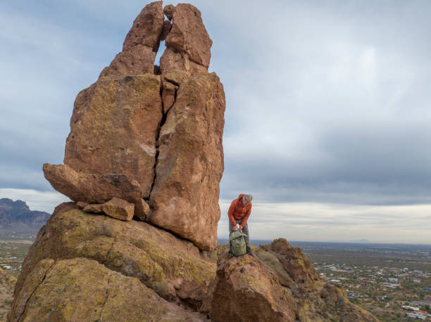istock Aerial view of hiker pausing on rock below spire 2191203610