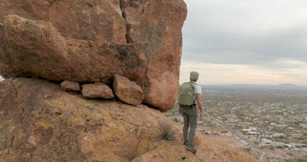 istock Aerial view of hiker pausing on rock below spire 2191203648