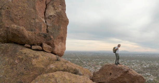 istock Aerial view of hiker pausing on rock below spire 2191203657