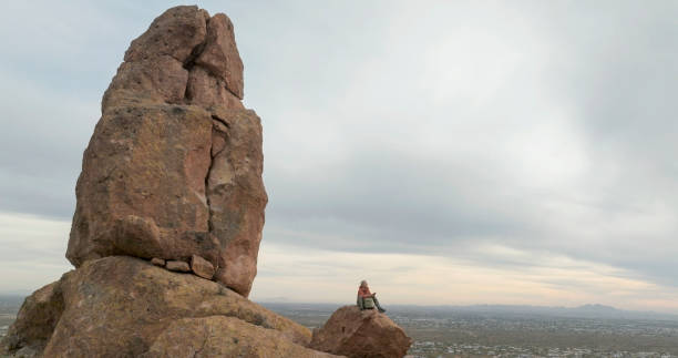 istock Aerial view of hiker pausing on rock below spire 2191203664