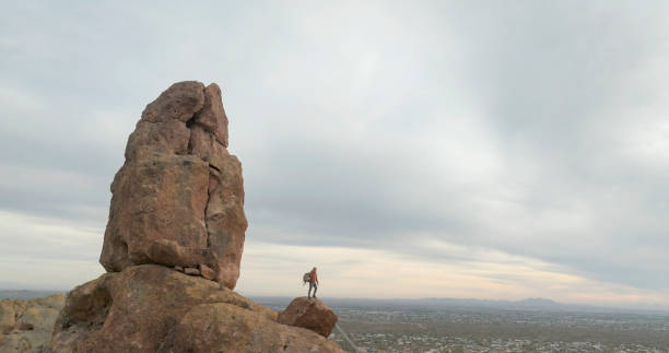 istock Aerial view of hiker pausing on rock below spire 2191203669