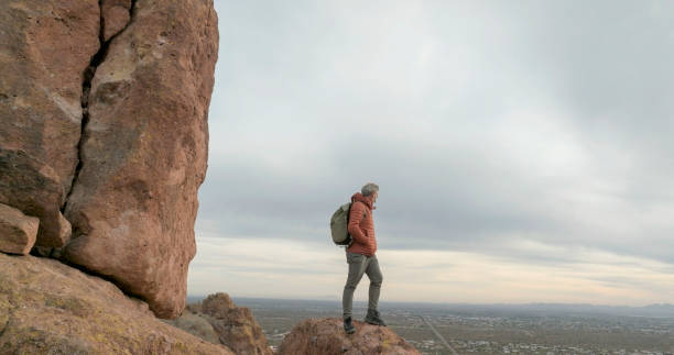 istock Aerial view of hiker pausing on rock below spire 2191203678