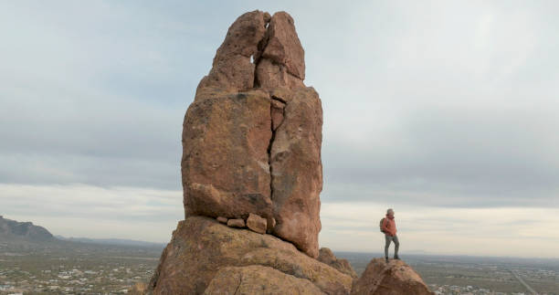 istock Aerial view of hiker pausing on rock below spire 2191203684