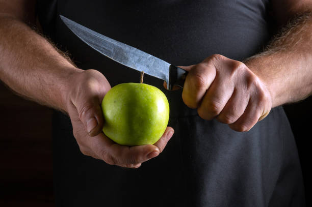 istock A person holds a bright green apple while expertly slicing it with a sharp knife. The atmosphere is warm and inviting, perfect for preparing delicious dishes or snacks 2191204780