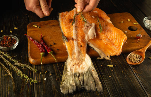 istock The chef expertly prepares salmon fillets at the kitchen table, using fresh herbs and spices for flavor and aroma 2191204867