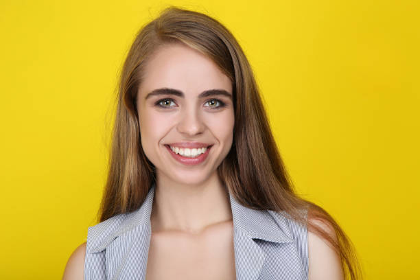 istock Young smiling girl on yellow background 2191205836