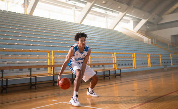istock Basketball player dribbling ball at court 2191206110