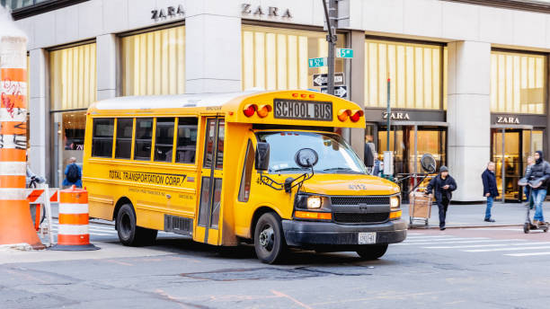 New York City, USA - December 6, 2023: Typical yellow school buses and people on the street near Upper East Side in New York City