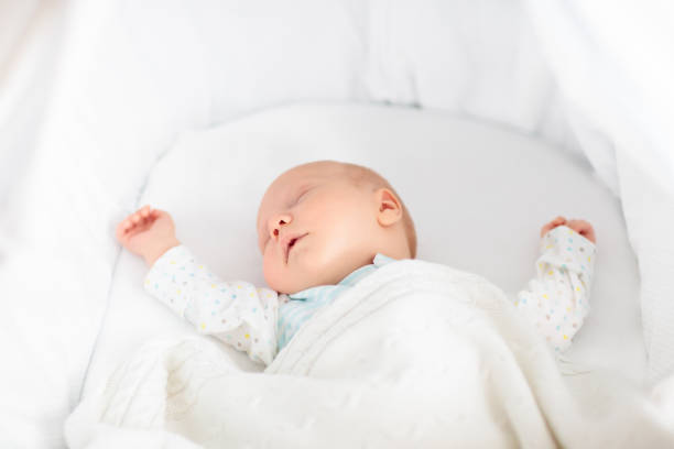 istock Cute newborn baby in white bed 2191211754