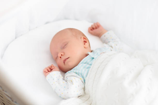 istock Cute newborn baby in white bed 2191211779