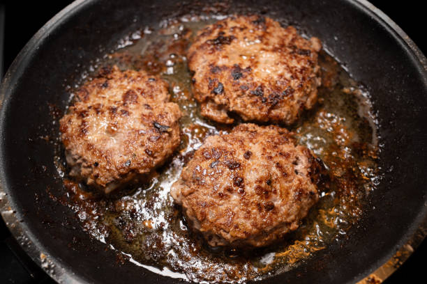 istock Three Swedish minced beef patties frying in butter in a pan 2191214366