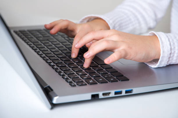 istock Children's fingers typing on the laptop keyboard. Learning concept. 2191215163