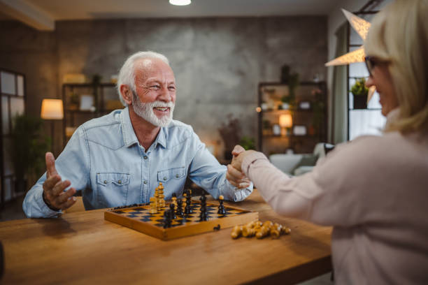 istock senior couple handshake after successful chess game on wooden table 2191219581