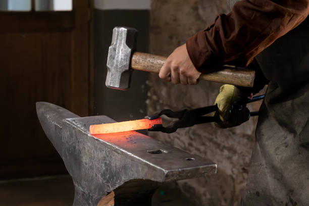 istock Craftsman - blacksmith manually forging the molten metal with a hammer 2191220397