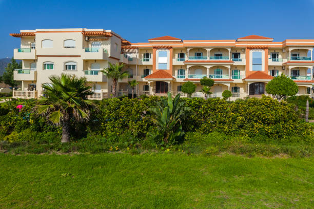 istock Mediterranean-style apartment complex with colorful facades, balconies, and lush greenery, set against a backdrop of a clear blue sky, creating a picturesque and inviting scene. 2191221637