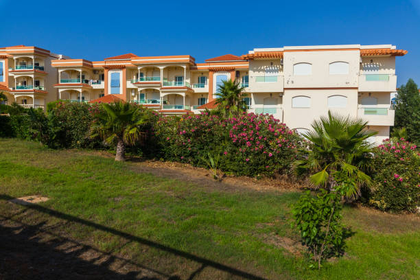 istock Mediterranean-style apartment complex with colorful facades, balconies, and lush greenery, set against a backdrop of a clear blue sky, creating a picturesque and inviting scene. 2191221652