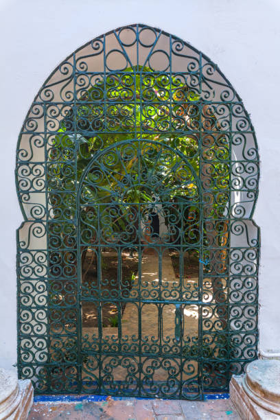 istock intricately wrought iron gate with swirling patterns, framing a lush green garden beyond, creating a captivating glimpse into a hidden oasis 2191223339