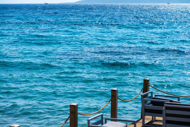 Comfortable seats and sofas arranged by the seaside under sunny skies, offering the perfect spot for relaxation and enjoying breathtaking ocean views.