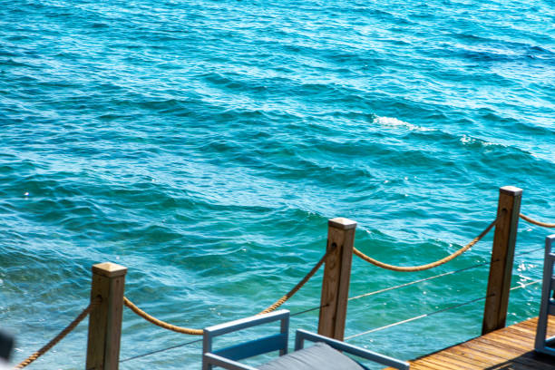 Comfortable seats and sofas arranged by the seaside under sunny skies, offering the perfect spot for relaxation and enjoying breathtaking ocean views.