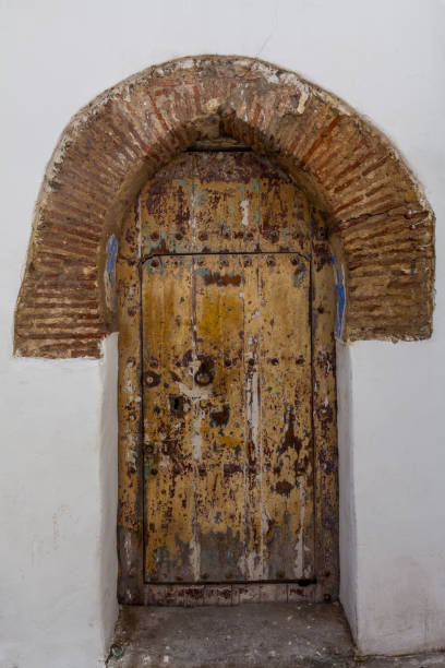istock weathered wooden door framed by an arched terracotta surround, creating a visually rich and texturally interesting entrance to a building in a historic setting 2191228005
