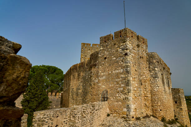 Ancient stone turret showing historical architecture as part of a medieval castle wall in Pals, Catalonia, Spain, under a clear blue sky, inviting tourism