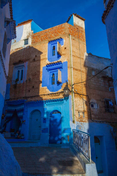 istock mix of blue and brick facades, featuring arched windows and doorways, situated along a sloping street 2191228947