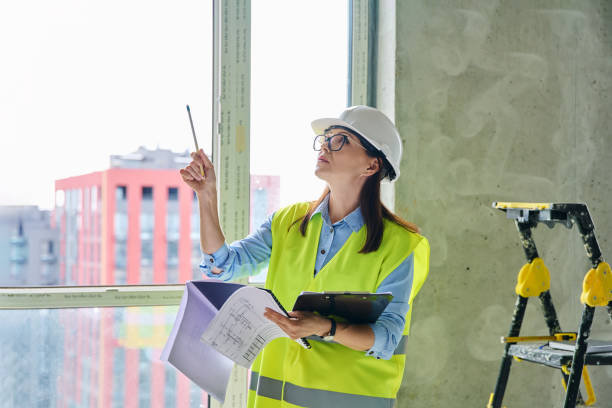 istock Technical profession woman in protective vest helmet working on construction 2191230156