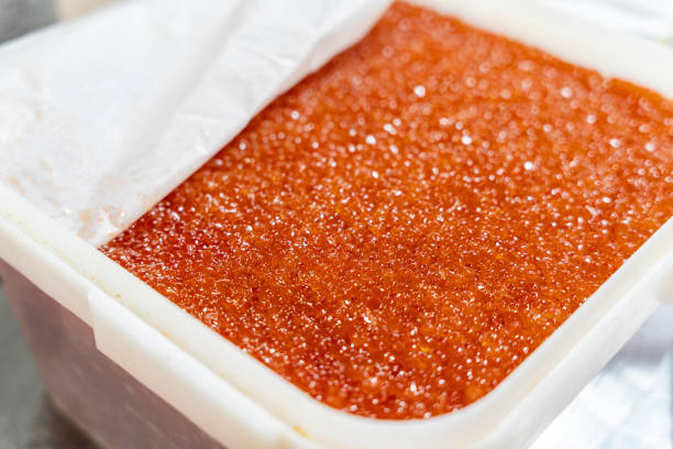 Fresh and moist natural red caviar. Red salmon caviar in a white container