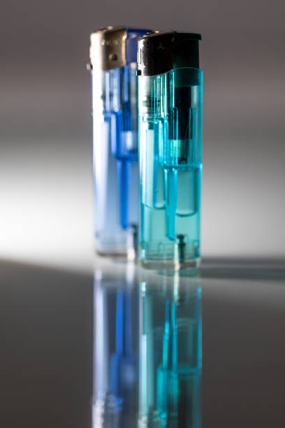 istock Two lighters in dark and light blue colors reflecting light on a smooth surface 2191245363