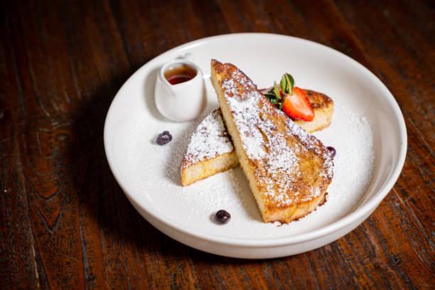 istock A plate of fench toast into triangular pieces with powdered sugar and garnished with a fresh strawberry and a sprig of mint 2191246731