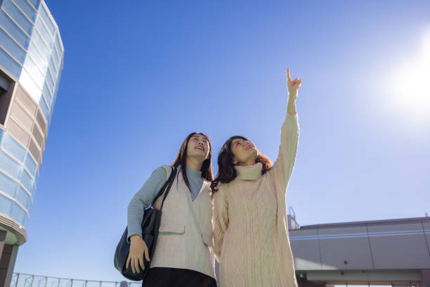 istock Female friends looking at sky from the rooftop 2191247157
