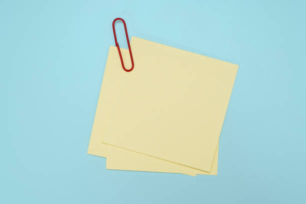istock Blank post it note with green paper clip isolated on blue. Sticky notes png texture pin memo reminder. 2191249655