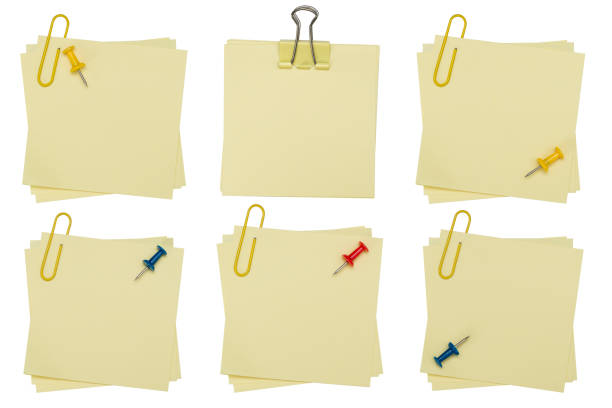 Blank post it note with green paper clip isolated on white. Collection yellow color post it paper with creases and curling on a white background. clipping path.